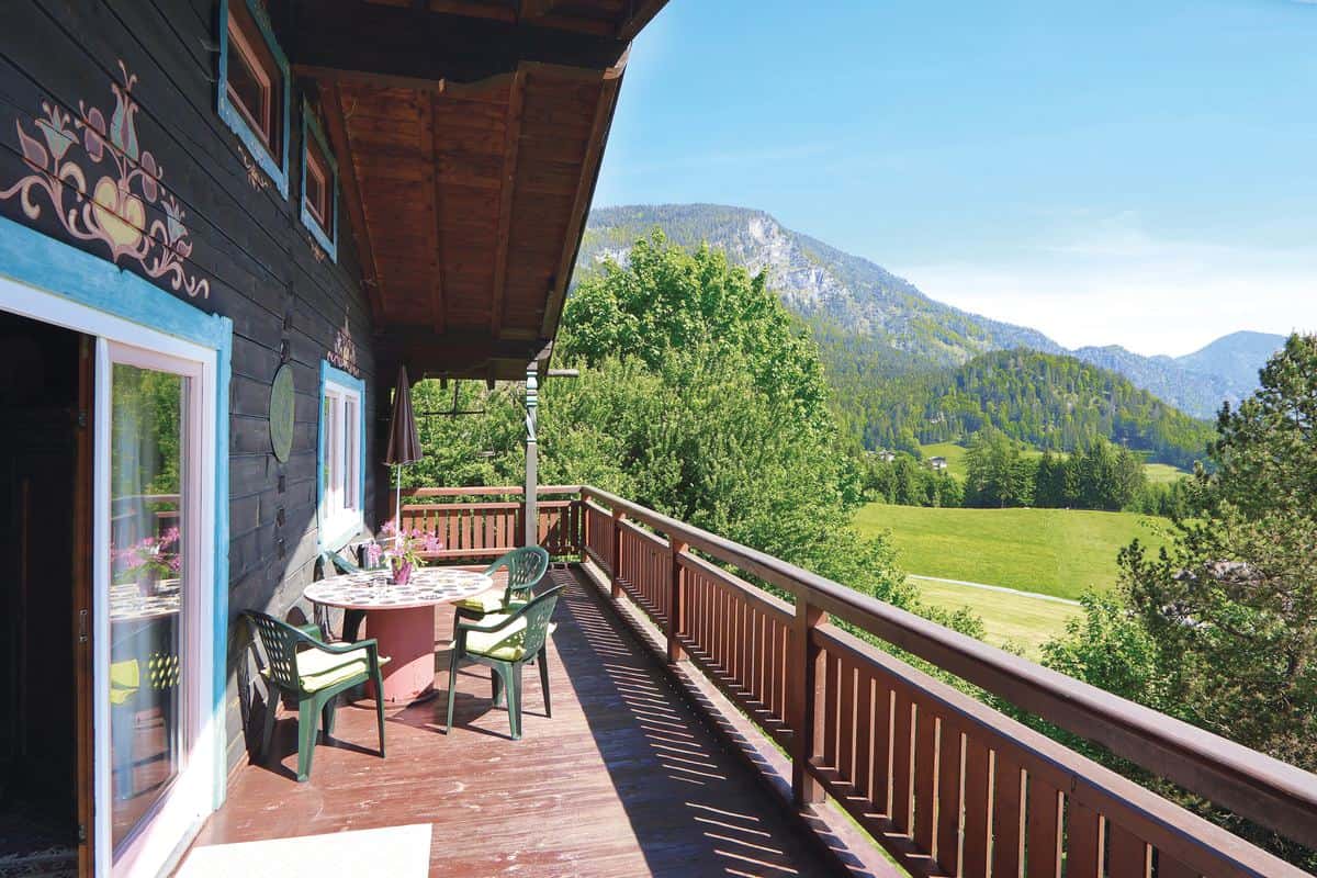 Balkon eines Bauernhauses in Unken mit Blick auf die bewaldeten Berge über dem Saalachtal