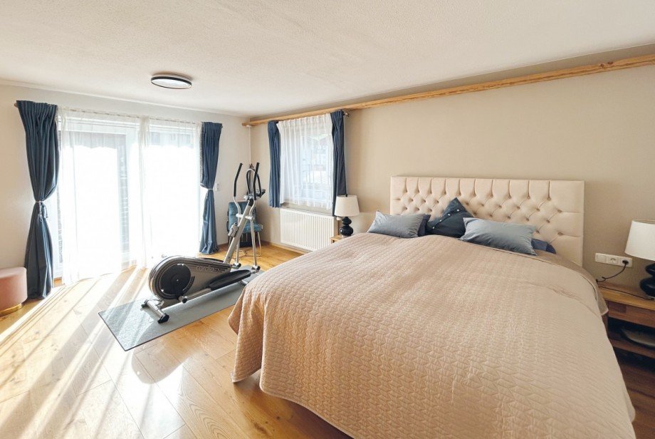 ger�umiges Schlafzimmer mit indirekt beleuchteten Einbauschr�nken und Zugang zum Balkon Maisonettewohnung Sankt Johann in Tirol